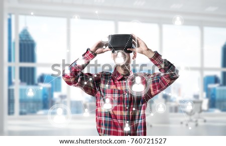 Young man with virtual reality headset or 3d glasses over connection background . Mixed media