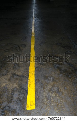Yellow line on concrete, sign in parking inside building
