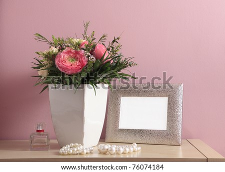 Bouquet of pink roses on pink background with an empty (blank) picture frame