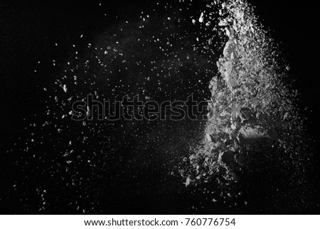Freeze motion of white particles on black background. Powder explosion. Abstract dust overlay texture.  
