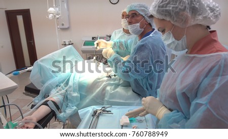Surgeons team working with Monitoring of patient in surgical operating room. Operation using laparoscopic equipment. Hospital.
