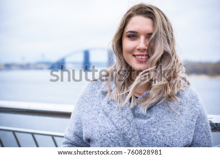 A woman of plus size, American or European appearance walks in the city enjoying life. A young lady with excess weight, stylishly dressed in coat at the center of the city. Natural beauty Royalty-Free Stock Photo #760828981