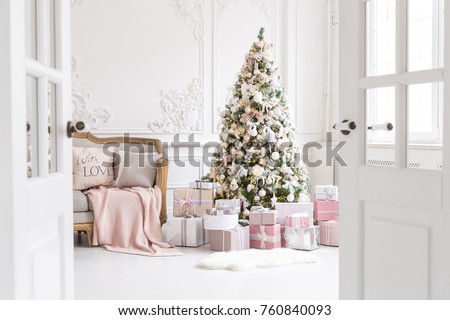 Luxury living room interior with sofa decorated chic Christmas tree, gifts, plaid and pillows.