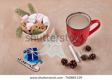 Christmas holiday background with gift box on the sled, coffee cup, cookies, cones, marshmallow, Christmas tree. Kraft paper background, View from above.