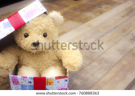 Cute teddy bear in the gift box on old wood background,Christmas and New Year's Day concept,copy space.