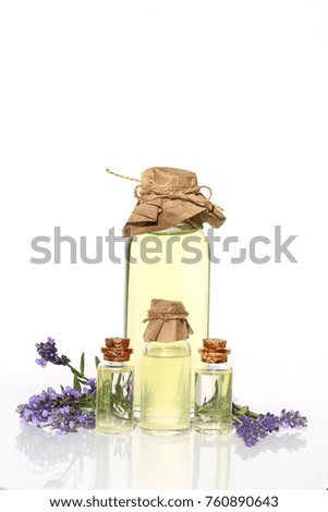 Lavender oil. Four transparent glass bottles with lavender oil, lavender flowers on a white background. Botanical cosmetics concept