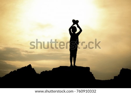 Silhouette of a girl standing. Raised Hands a heart.