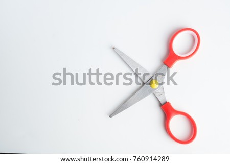 Small red scissors on white