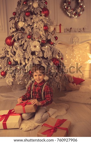 Young boy unwrapping presents on Christmas evening
