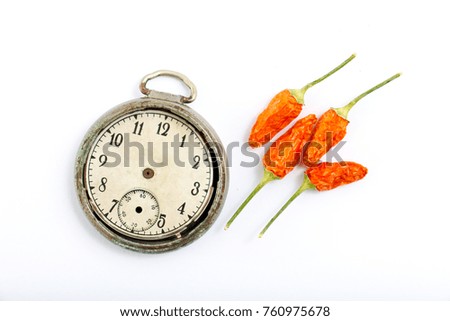 Dried chili  pepper and vintage clock isolated on white background .top view