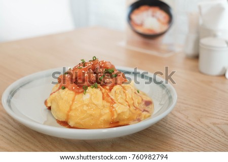 Close-up picture of Japanese food called Salmon Yukke Creamy Omu Rice, composed of thick egg topped with sliced salmon topped with sauce, Japanese food concept.