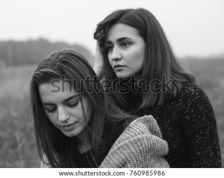 Two young  women are posing on the field. Black and white