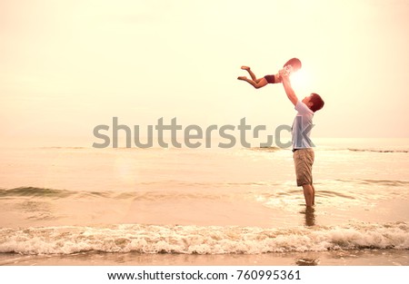 Asian father and little girl playing on the beach at the sunset, Dad holding daughter flying at the beach. Together love family concept. Father's day