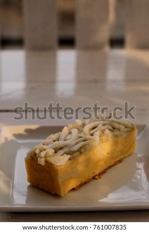Well designed coconut cake in white plate on white wood table in a restaurant, special designed recipe for adding value by topping with soft young coconut fruit for better taste and unique