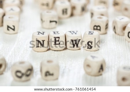 Word NEWS formed by wood alphabet blocks. On old wooden table.
