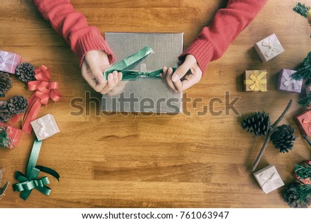 woman wearing santa hat packaging gift box, christmas concept