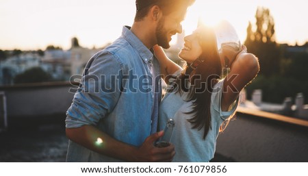 Couple flirting while having a drink on rooftop terrasse Royalty-Free Stock Photo #761079856