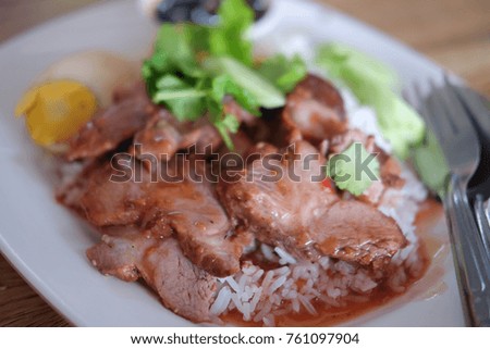 Barbecued red pork in sauce with rice on white dish