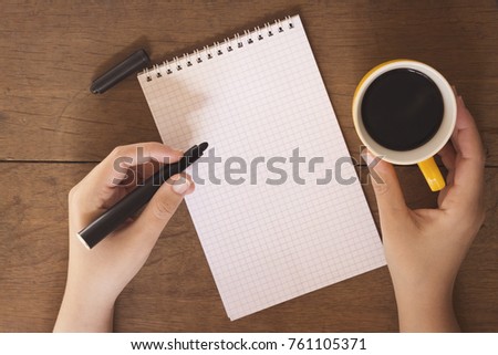woman hand holding and drinking a arabic coffee and writing
