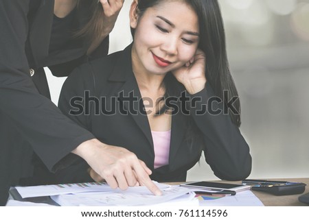happy Asian business woman working with teamwork analyzing on their financial graph at office with some paper,calculator and laptop on desk 