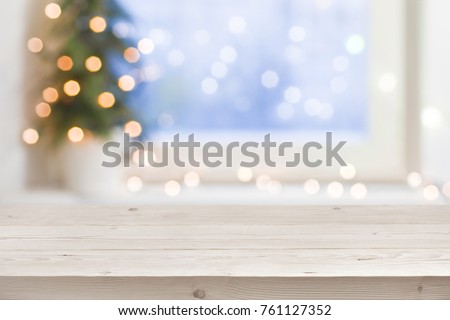 Empty wooden table in front of blurred winter holiday background