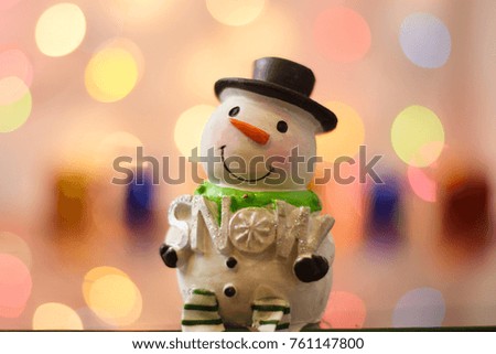 Snowman holding a Snow sign with bokeh background