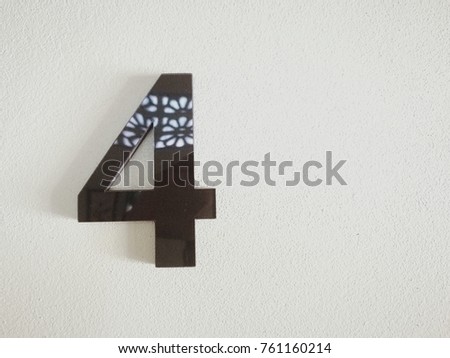 Metal black number four on white cement wall with copy space for text. Picture for create a new background with number four such as time, clock, calendar,date,fourth floor, room number, 
