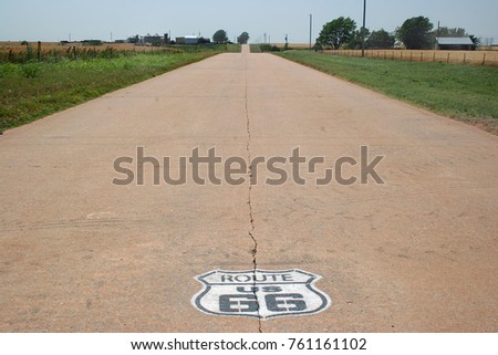 This is route 66 in western Oklahoma.  The painted sign on the road was placed by organizations wanting to make the trip through the state as easy and interesting as possible.