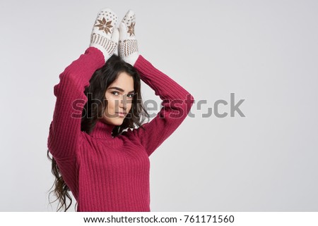 a woman in mittens is holding hands over her head