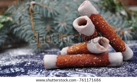 apple tubes placed on more of them winter christmas sweets - candies on the blue table cloth white snowflakes and bell painted on it