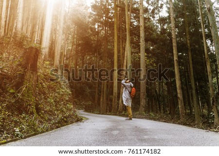 A man taking photograph in the natural park, in the morning with sun light ray