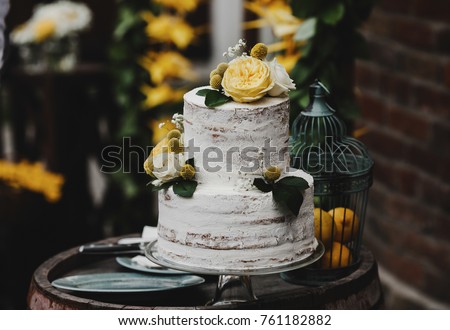 Beautiful wedding cake decorated with yellow flowers and greenery Royalty-Free Stock Photo #761182882