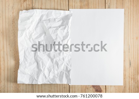 white paper and crumpled paper on wooden background