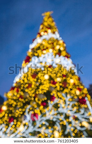 Blurred image of decorated Christmas trees for crowd of people to take photo on Christmas festival at front courtyard of Central World, the luxurious and modern shopping mall  