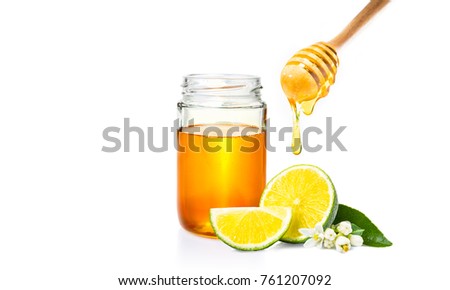 honey dipper with honey dripping down, honey jar, and cut fresh lime on isolated white background, room for adding text or copy space