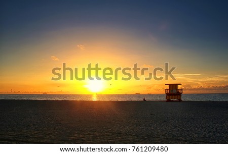 Lifeguard Tower on Ocean Beach at Sunset Silhouette with Colorful Sky