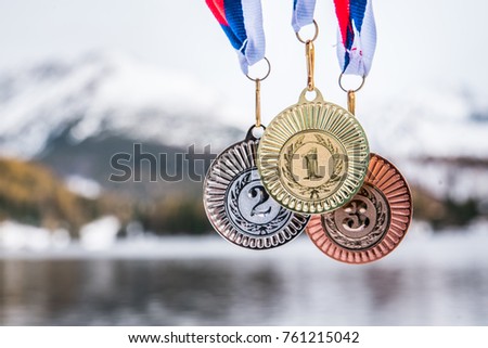 Gold, silver and bronze medal with winter nature in background. Sport trophy concept photo for winter game in South Korea Royalty-Free Stock Photo #761215042