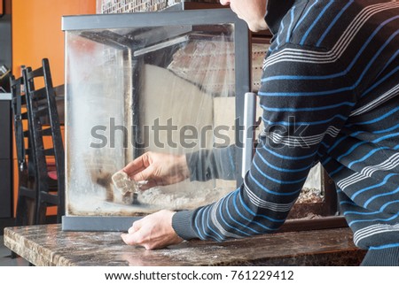 Man wipes the dirty glass of fireplace
