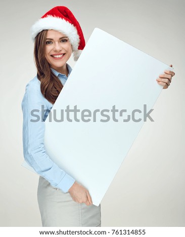 Woman wearing christmas hat holding big white banner, sign board. Isolated portrait.
