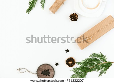 Christmas composition with gift, cup of coffee and fir brunches over white background. Flat lay, copy space 
