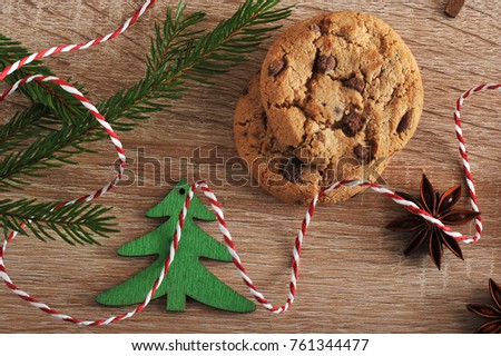 
Christmas composition of oatmeal cookies with pieces of chocolate, spruce branches, anise stars. Light wooden background. View from above. Close-up. Macro photography.