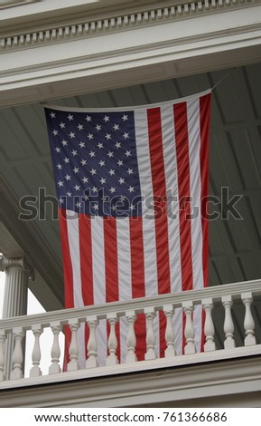 Portrait picture of a United States of America flag hanging on veranda, captured in Charleston, South Carolina, USA