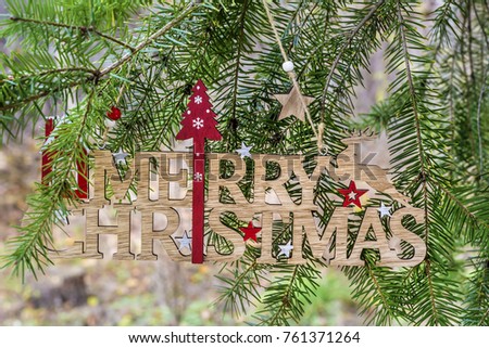 Merry Christmas Wooden Sign Hanging on a Pine Tree .Christmas Card