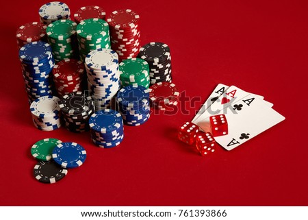 Casino gambling poker equipment and entertainment concept - close up of playing cards and chips at red background. Three of a Kind
