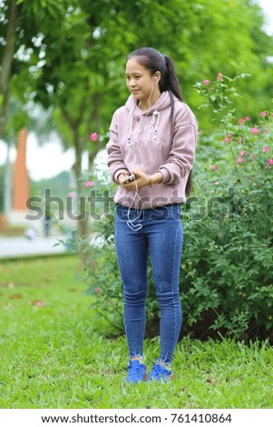 The woman listening to music on a smartphone