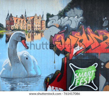 A fragment of detailed graffiti of a drawing made with aerosol paints on a wall of concrete tiles. Background image of street art with a huge white swan