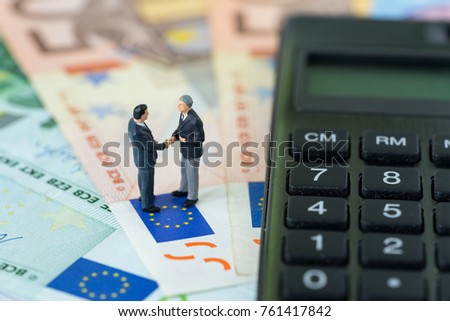 Miniature figure, businessmen shaking hand standing on pile of Euro banknotes with calculator as Euro economy agreement or Brexit negotiation concept.