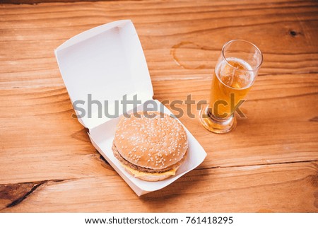 Fresh and juicy hamburger and beer on wooden background