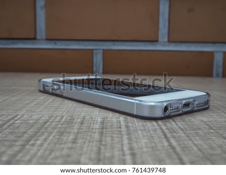 Smartphone with a brick wall on a wood table.