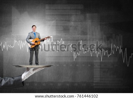 Hand of waiter presenting on tray man playing guitar